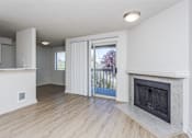 Thumbnail 12 of 20 - A room with a fireplace and a sliding glass door leading outside.