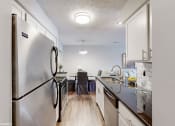 Thumbnail 17 of 46 - an open kitchen and dining room with stainless steel appliances and white cabinets at Island Club Apartments, Columbus, Ohio
