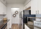 Thumbnail 16 of 46 - a kitchen with white cabinets and stainless steel appliances at Island Club Apartments, Columbus, 43235