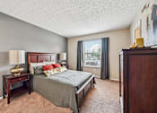 Thumbnail 9 of 24 - A bedroom with a large bed and a window overlooking a balcony.