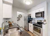 Thumbnail 5 of 46 - a kitchen with stainless steel appliances and white cabinets at Island Club Apartments, Columbus