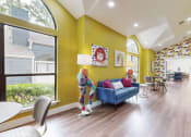 Thumbnail 3 of 24 - a living room with yellow walls and a blue couch at The Vale Apartments and Townhomes, Tennessee