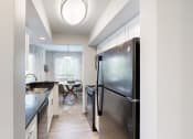Thumbnail 7 of 35 - a kitchen with stainless steel appliances and a dining room with a table at Runaway Bay Apartments, Columbus, OH