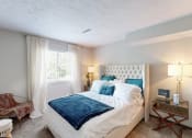 Thumbnail 10 of 35 - a bedroom with a bed and a chair and a window at Runaway Bay Apartments, Columbus, Ohio
