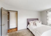 Thumbnail 9 of 46 - a bedroom with a bed and a door to a bathroom at Island Club Apartments, Columbus, OH