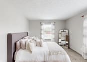 Thumbnail 11 of 46 - a bedroom with a bed and a window and a mirror at Island Club Apartments, Columbus
