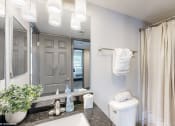Thumbnail 20 of 46 - a bathroom with a large mirror and a toilet and a sink at Island Club Apartments, Ohio