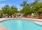 Thumbnail 11 of 24 - our resort style swimming pool is next to our yard with chairs and trees at The Vale Apartments and Townhomes, Cordova, TN