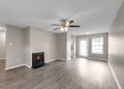 Thumbnail 4 of 19 - A spacious room with a fireplace and a ceiling fan.