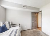 Thumbnail 22 of 46 - a bedroom with a bed and a door to a bathroom at Island Club Apartments, Columbus, OH, 43235