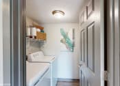 Thumbnail 9 of 35 - a laundry room with a washer and dryer and a blue door at Runaway Bay Apartments, Columbus, 43204