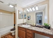 Thumbnail 10 of 24 - A bathroom with a brown countertop and a white sink.