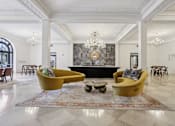 Thumbnail 1 of 26 - A large room with a yellow couch and a chandelier.