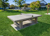 Thumbnail 30 of 46 - A concrete table in a grassy area with a house in the background at Island Club Apartments, Columbus, OH, 43235