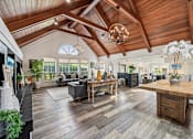 Thumbnail 4 of 24 - A spacious living room with a wooden ceiling and a large wooden coffee table.