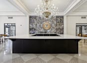 Thumbnail 2 of 26 - A large, elegant kitchen with a marble backsplash and a chandelier.