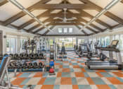 Thumbnail 32 of 35 - a gym with weights and cardio equipment in a building with windows at Runaway Bay Apartments, Columbus, OH
