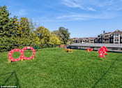 Thumbnail 26 of 46 - A grassy field with a red fire hydrant and a large red circle with white rings. at Island Club Apartments, Columbus, Ohio