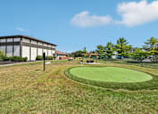 Thumbnail 20 of 24 - A golf course with a green and a flag on it.