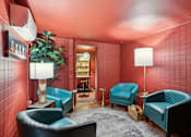 Thumbnail 9 of 26 - A room with red walls and blue chairs.