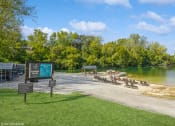 Thumbnail 19 of 35 - a park with a beach and a sign next to a lake at Runaway Bay Apartments, Columbus