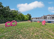 Thumbnail 23 of 24 - A grassy area with a pink sculpture and a building in the background.