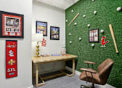 Thumbnail 12 of 26 - A room with a green wall and a wooden desk with a chair.