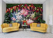 Thumbnail 17 of 26 - Two yellow couches in front of a floral mural.