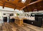 Thumbnail 44 of 46 - A modern living room with a wooden floor and a high ceiling at Island Club Apartments, Columbus, OH, 43235