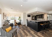 Thumbnail 40 of 46 - A modern living room with a bar area and a dining table at Island Club Apartments, Columbus, Ohio
