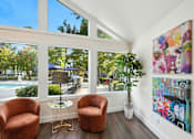 Thumbnail 17 of 19 - Two brown chairs are placed in front of a wall with a painting and a potted plant.