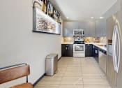 Thumbnail 11 of 20 - A modern kitchen with stainless steel appliances and a wooden bench.