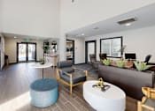 Thumbnail 7 of 20 - A modern waiting room with a blue ottoman and wooden chairs.