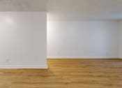 Thumbnail 15 of 20 - A room with wooden floors and white walls.