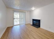 Thumbnail 16 of 20 - A room with a fireplace and a sliding glass door.
