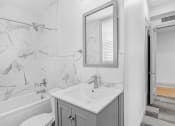 Thumbnail 25 of 25 - White marbled bathroom with a sink and a mirror at 275 on the Park Apartments, Missouri, 63108