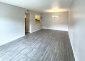 Thumbnail 11 of 12 - an empty living room with wood flooring and white walls at Cambridge Village Apartments, Houston Texas ? 