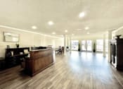 Thumbnail 7 of 12 - a lobby with a reception desk and a large room with hard wood floors at Cambridge Village Apartments, Texas ? 