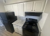 Thumbnail 12 of 17 - a kitchen with white cabinets and black stove and refrigerator at Whispering Oaks, Conroe, TX ? 