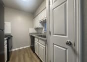 Thumbnail 14 of 17 - a kitchen with white cabinets and a white door at Whispering Oaks, Conroe, 77301 ? 