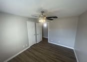 Thumbnail 17 of 17 - a bedroom with a ceiling fan and a door to a closet at Whispering Oaks, Conroe Texas ? 