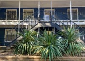 Thumbnail 7 of 17 - a blue building with stairs and plants in front of it at Whispering Oaks, Conroe, TX 77301 ? 