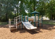 Thumbnail 4 of 9 - a playground with a slide and climbing equipment in a park at The Grove Germantown Apartments, Germantown, TN ?