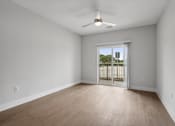 Thumbnail 31 of 35 - an empty living room with wood flooring and a sliding glass door to a balcony at The Virginia, Seguin, 78155