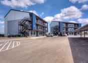 Thumbnail 33 of 65 - Building Exterior with Blue Skies at Aviator at Brooks Apartments, San Antonio