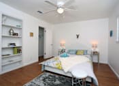 Thumbnail 4 of 13 - A bedroom with a bed, a chair, and a ceiling fan.