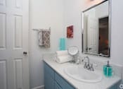 Thumbnail 8 of 13 - A bathroom with a white sink and a mirror.