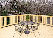 Thumbnail 7 of 13 - A table and chairs set on a wooden deck.