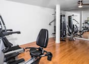 Thumbnail 11 of 13 - A gym with a variety of equipment including a treadmill, a stationary bike, and a rowing machine.