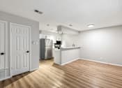 Thumbnail 24 of 30 - A kitchen with white cabinets and a wooden floor.